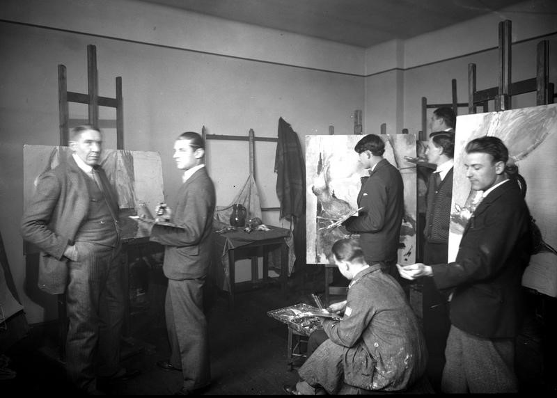 Studenci podczas zajęć z malarstwa w pracowni profesora Stanisława Kamockiego (stoi z lewej), źródło: Narodowe Archiwum Cyfrowe